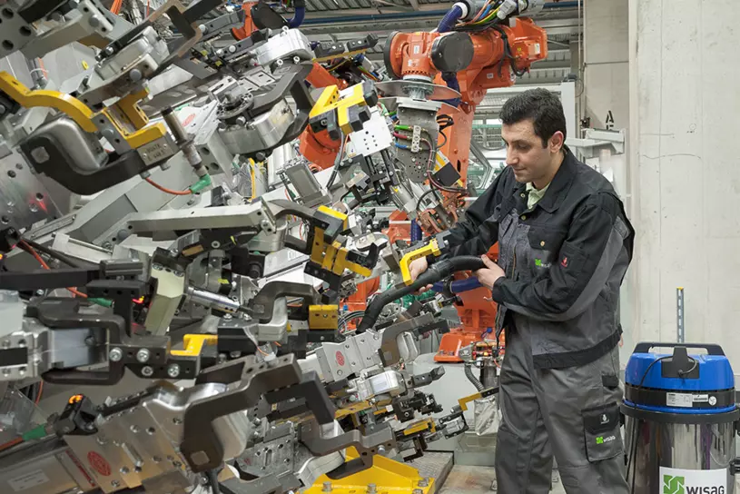 WISAG Mitarbeiter beim Reinigen einer Produktsmaschine