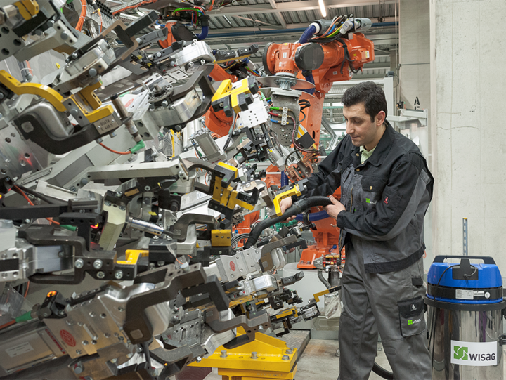 WISAG Mitarbeiter beim Reinigen einer Produktsmaschine