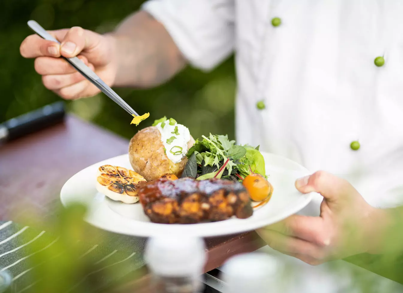 WISAG Mitarbeiter richtet einen Teller mit Essen an