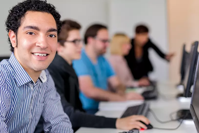 Person sitzt an PC und nimmt an Schulung teil