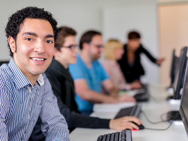 Person sitzt an PC und nimmt an Schulung teil