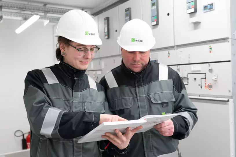 Zwei WISAG Mitarbeiter vor Niederspannungsschaltanlage