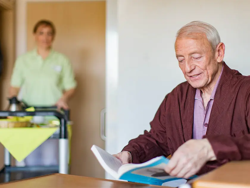 WISAG Mitarbeiter verpflegt älteren Herren