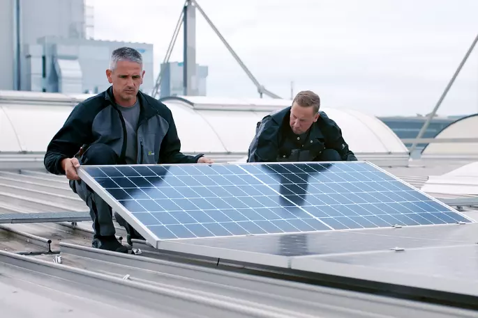 Zwei Personen installieren eine Solaranlage